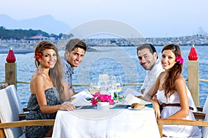 Two happy couples having dinner at the seaside