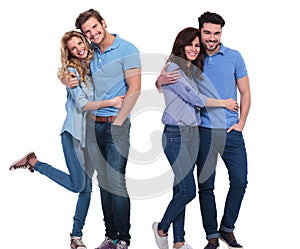 Two happy couples of young casual people standing embraced