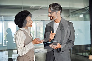 Two happy diverse professional business team people talking in office.