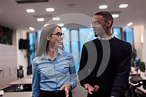 Two happy diverse professional executive business team people woman and African American man walking in coworking office