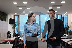 Two happy diverse professional executive business team people woman and African American man walking in coworking office