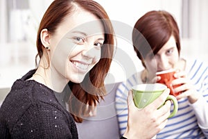 Two happy female friends with coffee cups