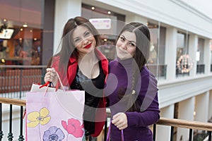 Two happy friends shopping in mall