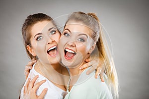 Two happy friends women hugging