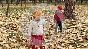 Two happy funny children kids boy Girl walking in park forest enjoying autumn fall nature weather. Kid Collect falling