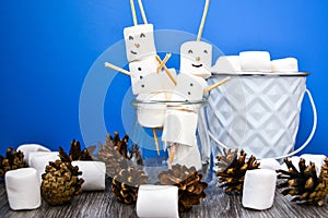 Two happy funny marshmallow snowmen. Marshmallow friends on blue background. Diy. Sweet treat for kids funny marshmallow snowman