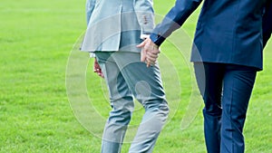 Two happy gay men holding hands and walking outdoors. Happy gay couple