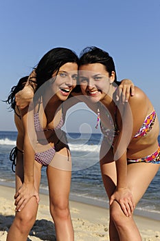 Two happy girl friends on the beach