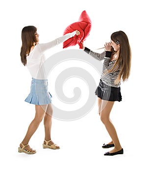 Two happy girlfriends fighting a pillows