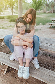 Two happy girlfriends hugging in the park. Two best friends females. Women sorority