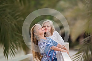 Two happy girls as friends hug each other in cheerful way. Little girlfriends in park. Children Friendship Together Smiling