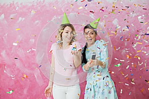 Two happy girls celebrate birthday party with cupcake confetti a