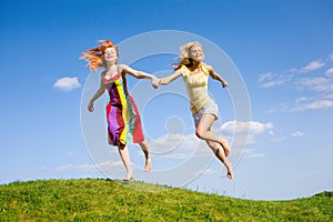 Two happy girls fleeing on a meadow.