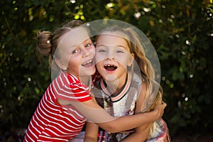 Two happy girls hugging girlfriend