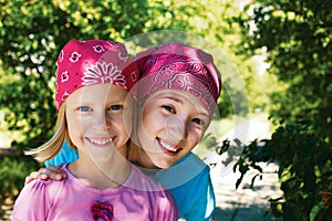 Two happy girls outdoors in kerchiefs on their heads