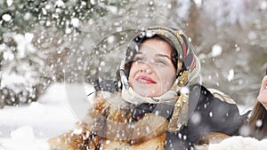 Two happy girls smiling and throwing up snow in the park. Slowly