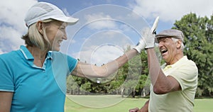 Two happy golfers giving high five