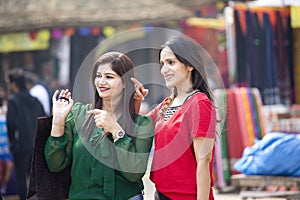 Two happy Indian women shopping at street market