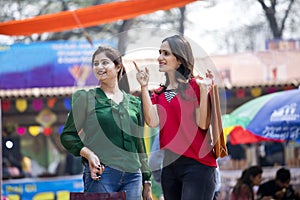 Two happy Indian women shopping at street market