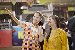 Two happy Indian women shopping at street market