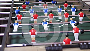 Two happy and joyful friends together playing table football in the playing center. Table football in the entertainment