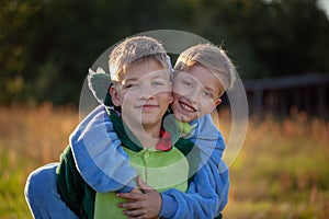 Two happy kids boys, funny siblings fun together. Brothers playing outdoors in summer day, best friends concept