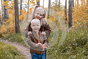 two happy kids brother and sister hugging in nature in autumn