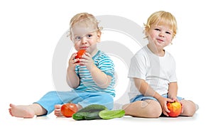 Two happy kids eating healthy food fruits and vegetables