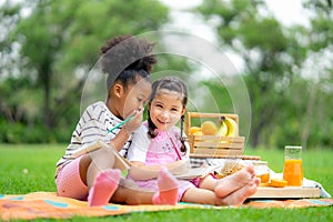 Two Happy kids relaxing on picnic in summer park and whispering. Healthy lifestyles concept