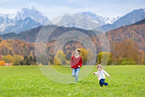 Two happy laughing kids in field between mountains