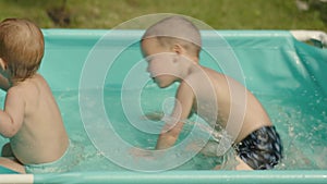 two happy laughing kids swim splash water blue pool outdoors backyard summer day