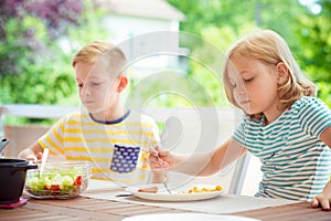 Two happy little children eating healthy breakfast at home