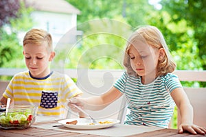 Two happy little children eating healthy breakfast at home
