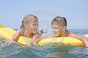 Two happy little children playing on the beach at the day time