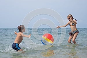 Two happy little children playing on the beach at the day time