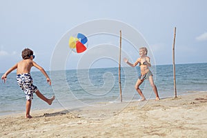 Two happy little children playing on the beach at the day time