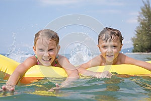 Two happy little children playing on the beach at the day time