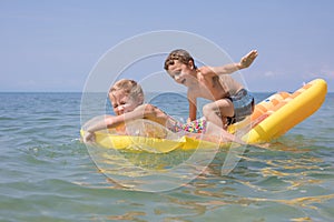 Two happy little children playing on the beach at the day time