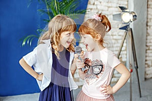 Two happy little children sing a song in karaoke. The concept is photo