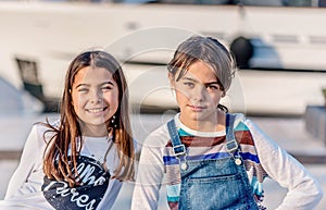 Two happy little girl smiling and looking at the camera