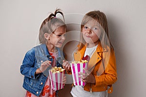 two happy little girls eating sweet popcorn