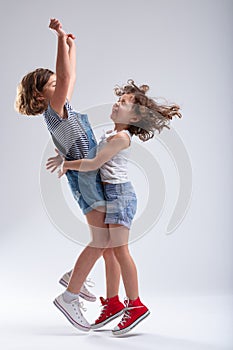 Two happy little girls hugging and jumping