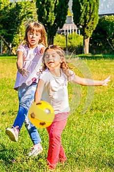 Two happy little girls playing in the park