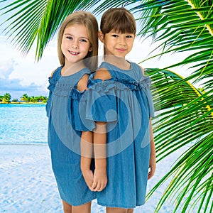 Two happy little girls posing on tropical beach