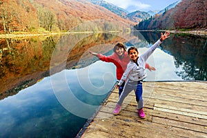 Two happy little girls standing on the pier of Lake Biograd (Bi