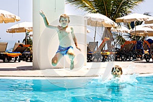 Two happy little kids boys jumping in the pool and having fun on family vacations in a hotel resort. Healthy children