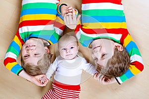 Two happy little preschool kids boys with newborn baby girl