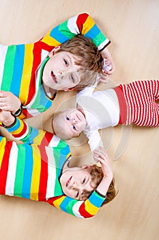 Two happy little preschool kids boys with newborn baby girl, cute sister. Siblings, twins children and baby playing
