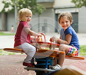 Two happy little sisters on teetering board