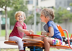 Two happy little sisters on teetering board